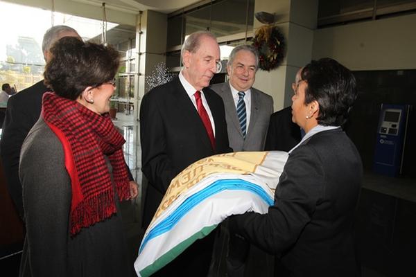 Florentino Fernández  recibe el pabellón nacional de manos de Mayra González, del Programa Cívico Permanente del Banco Industrial. (Foto Prensa Libre: Edwin Castro)