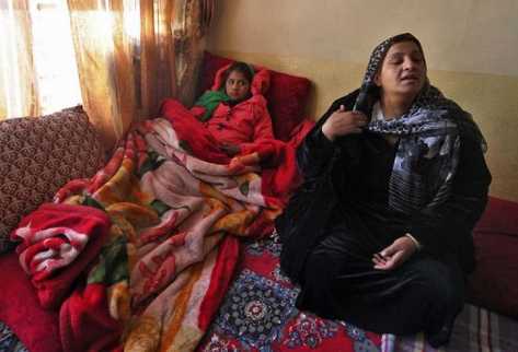 Tarana Akbari (I), de 12 años, descansa en su hogar en Kabul el 10 de diciembre de 2011. (AFP).