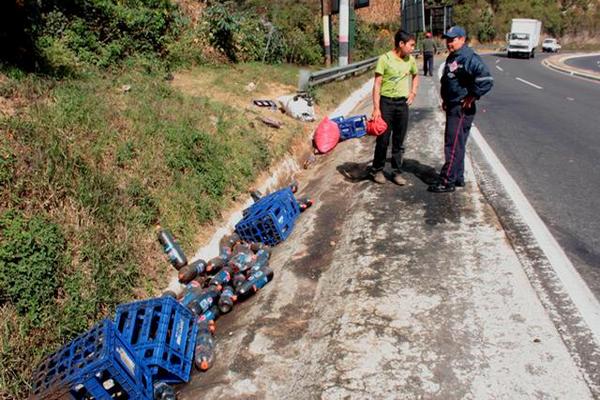 Un tráiler que transitaba en Sumpango, Sacatepéquez se le desprendió la plataforma que halaba un cargamento de aguas gaseosas, las cuales cayeron e hirieron a un padre y su hijo. (Foto Prensa Libre: Víctor Chamalé)<br _mce_bogus="1"/>