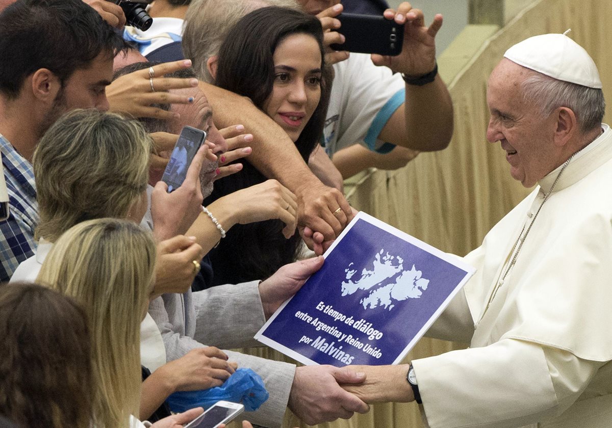 <em>Momento en el que el Papa sostiene brevemente el rótulo a favor del diálogo por las Malvinas.(Foto Prensa Libre: AP).</em>