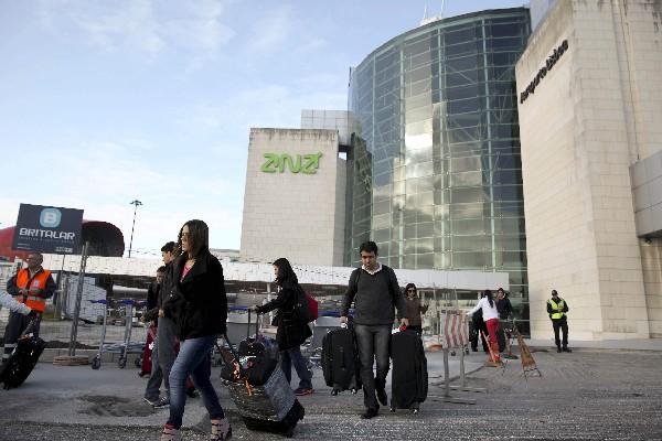 Pasajeros salen del aeropuerto de Lisboa, Portugal,  el cual vendió el  Gobierno al grupo francés Vinci. (Foto Prensa Libre: EFE)