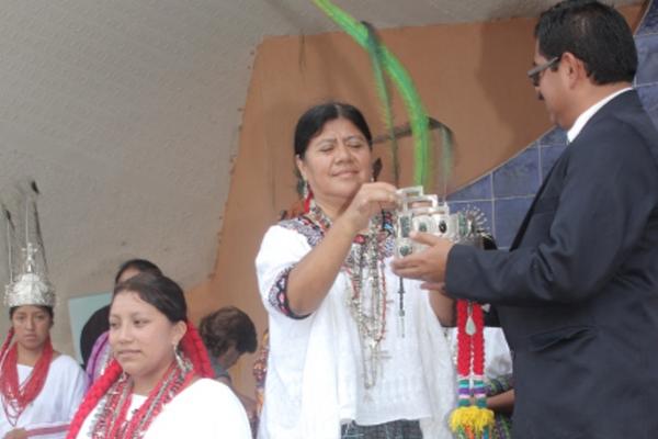 Una integrante del comité despoja de la corona a la actual Rabín Ajaw, Lesly Yesenia Tupil Tzub, izquierda, y la entrega al presidente del Festival Folklorico Nacional. (Foto Prensa Libre: Ángel Martín Tax)