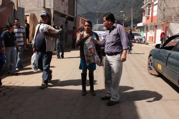 Luis Rivera, gobernador departamental, entrega ayuda a una damnificada  en en San Pedro Sacatepéquez. (Foto Prensa Libre: Aroldo Marroquín)<br _mce_bogus="1"/>