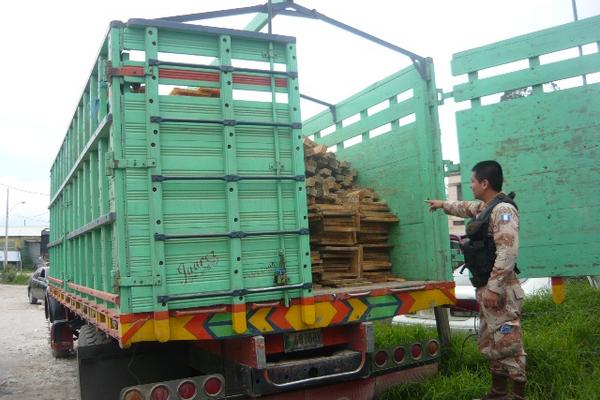 Un agente de Diprona señala parte de la madera decomisada en San Pedro Sacatepéquez. (Foto Prensa Libre: Genner Guzmán)<br _mce_bogus="1"/>