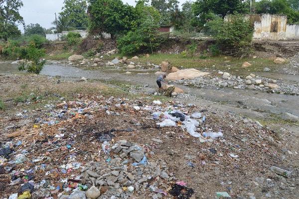 Vecino de Zacapa tira basura en un riachuelo.