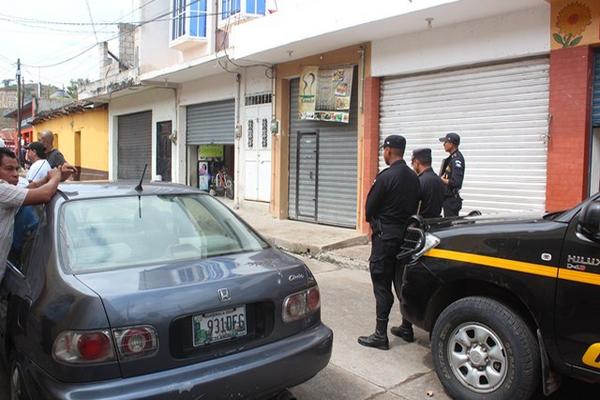 Agentes de la PNC vigilan frente al taller de motocicletas, en cuyo interior murió baleado el propietario Fredy de Jesús Reyes, en Ipala. (Foto Prensa Libre: Edwin Paxtor)