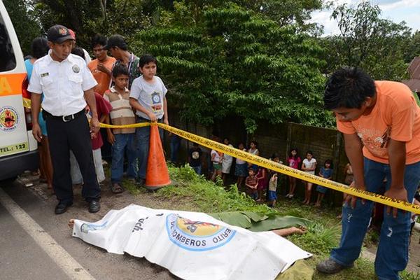 Curiosos observan el cadáver de Luis Tomás Aguilar, quien murió atropellado, en San Antonio Suchitepéquez. (Foto Prensa Libre: Omar Méndez)