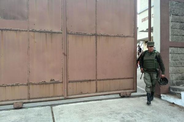 Un guardia cierra el portón del inmueble donde ocurrió el incidente. (Foto Prensa Libre: Erick Avila)