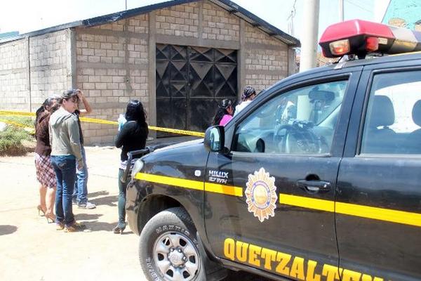 Familiares de la víctima esperan fuera de la bodega. (Foto Prensa Libre: Carlos Ventura)<br _mce_bogus="1"/>