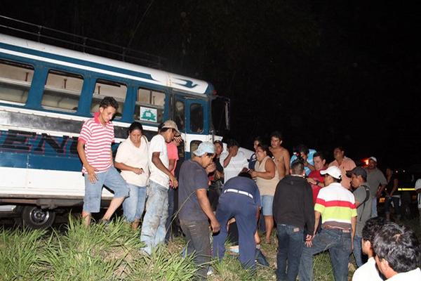 Pobladores de Santa Cruz Mulua, Retalhuleu observan el cuerpo del piloto asesinado esta noche, cuando conducía un bus de los transportes Providencia. (Foto Prensa Libre: Rolando Miranda)<br _mce_bogus="1"/>