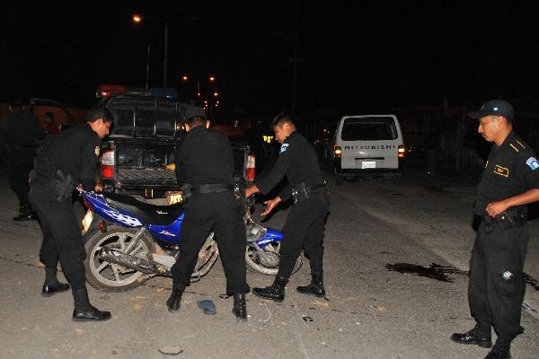 Agentes de la Policía levantan la motocicleta.