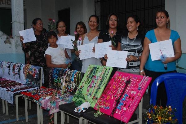 Las participantes   muestran el diploma  y los artículos que elaboraron.