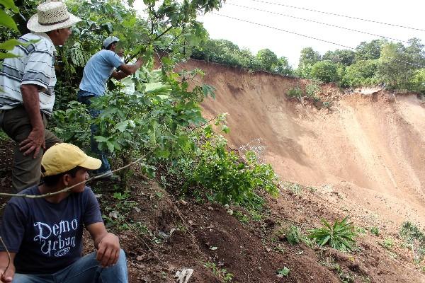 Vecinos observan las  toneladas de tierra y árboles que se deslizaron del cerro Las Doncellas.