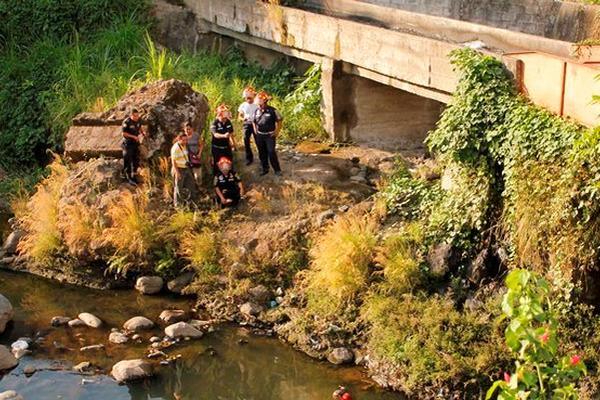 Socorristas observan el cadáver de un hombre encontrado en el río Sis en Mazatenango. (Foto Prensa Libre: Omar Méndez) <br _mce_bogus="1"/>