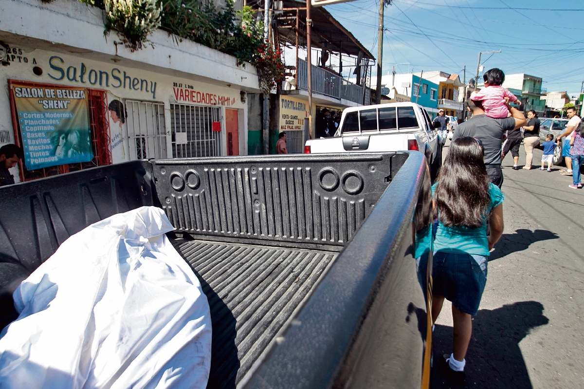 Agentes de la Policía trasladan el cuerpo de Edwin Rivera, de 40 años, quien murió lapidado en la colonia La Reinita, zona 6 capitalina.