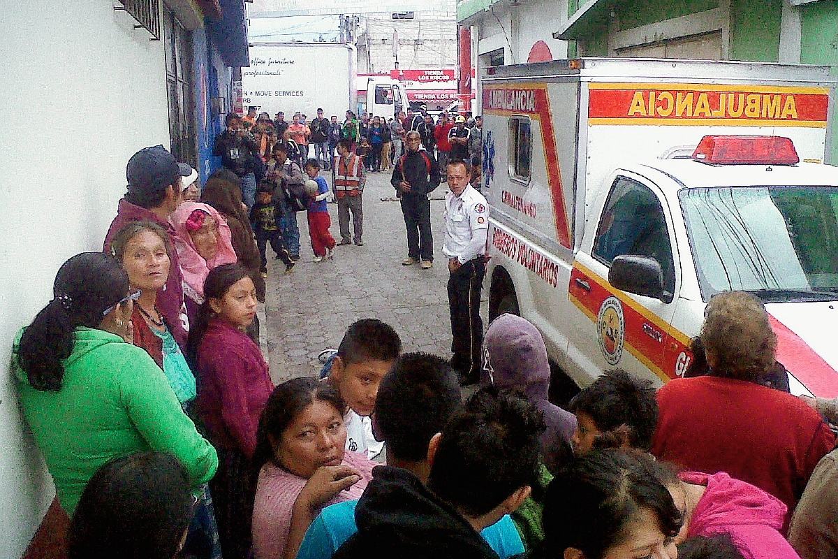 Vecinos y socorristas observan el cadáver de un hombre, en la cabecera de Chimaltenango. (Foto Prensa Libre: Víctor Chamalé)