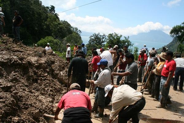 Organizados, los vecinos intentan despejar trayecto bloqueado por derrumbe en Sololá. (Foto Prensa Libre: Édgar Sáenz)<br _mce_bogus="1"/>