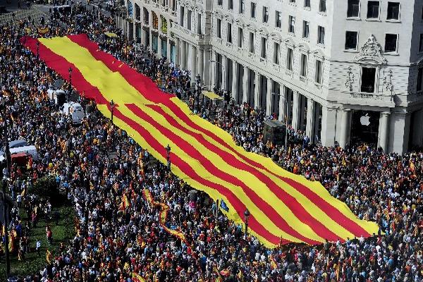 Cientos se manifestaron en Barcelona, al desplegar una bandera gigante de Cataluña-España. (Foto Prensa Libre: AFP)