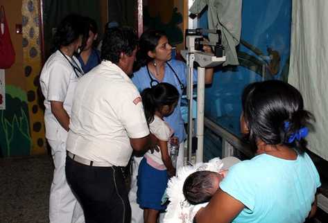 Socorristas trasladan a las niñas a un centro asistencial al resultar intoxicadas por comer semillas de piñon. (Foto Prensa Libre: Rolando Miranda)