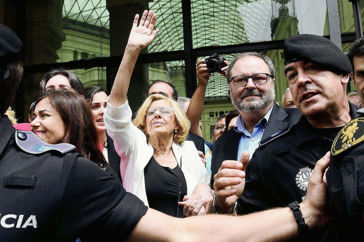 Manuela Carmena (al centro, de blanco), saluda a simpatizantes despues de salir del recinto donde se efectuó la votación donde ella resultó electa para dirigir la alcaldía de Madrid. (Foto Prensa Libre: AFP).