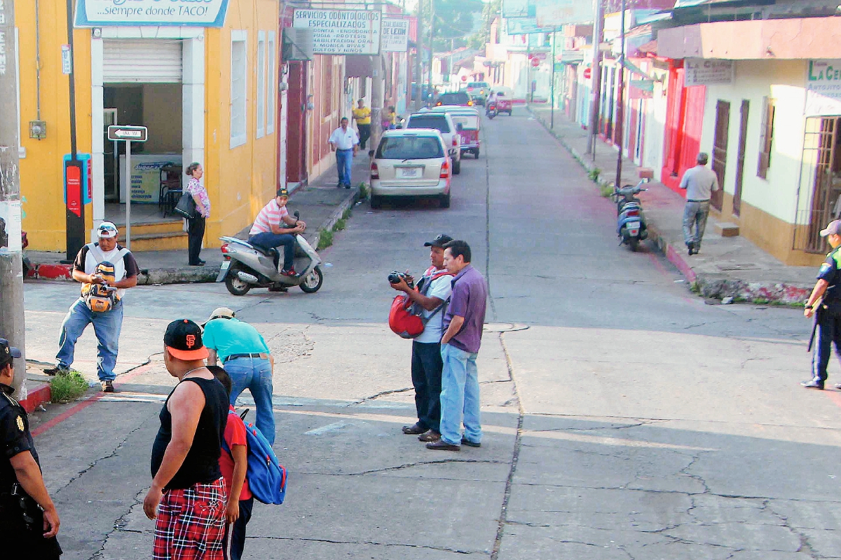 Vecinos de  la zona 1 de Retalhuleu observan el lugar en  donde fue hallado el cadáver de un hombre. (Foto Prensa Libre: Rolando Miranda)