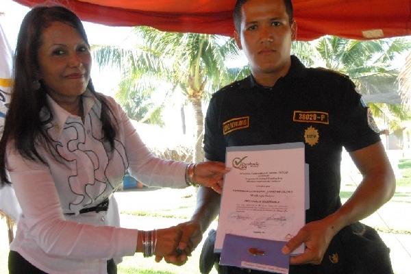 Un agente de la Policía que participó en el curso impartido por el Inguat en Taxisco, Santa Rosa,  recibe un diploma por su destacada participación.