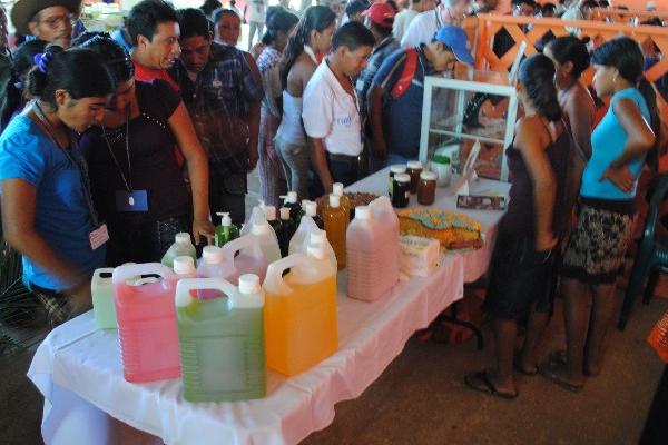 Las mujeres muestran productos de limpieza que han elaborado durante la capacitación.