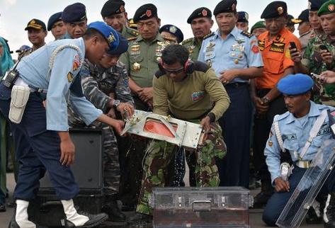 Autoridades indonesias con una de las cajas negras del vuelo QZ8501 de AirAsia. (Foto Prensa Libre: AFP)