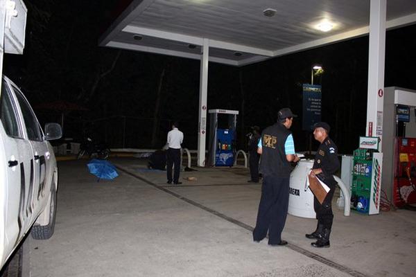 Autoridades examinal el lugar donde fue baleado Juan Carlos Oliva, en una gasolinera de Morales, Izabal. (Edwin Perdomo)