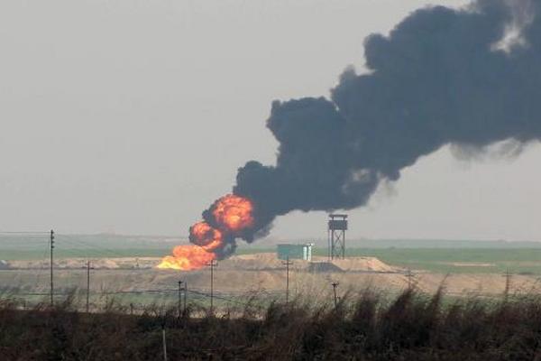 Humo procedente del campo petrolífero de Khubaz que cayó en manos del Estado Islámico. (Foto Prensa Libre: AFP)