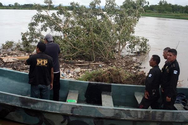 Fiscales del Ministerio Público y agentes policiales participan en el rescate de uno de los cadáveres que aparecieron flotando en el río Motagua, en Puerto Barrios, Izabal. (Foto Prensa Libre: Edwin Perdomo)<br _mce_bogus="1"/>