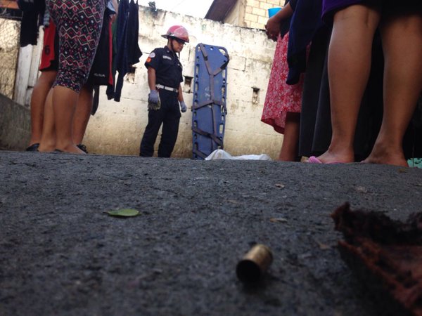 Un bombero cubre el cadáver a la vista de vecinos en la colonia Ciudad Real, zona 12. (Foto Prensa Libre: Cortesía CBM)