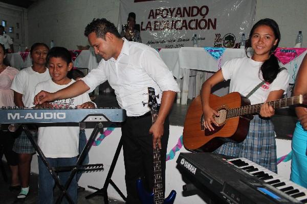 Niños y jóvenes prueban los instrumentos que fueron adquiridos para la academia de arte.