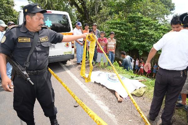 Curiosos observan el cadáver de Aguilar.