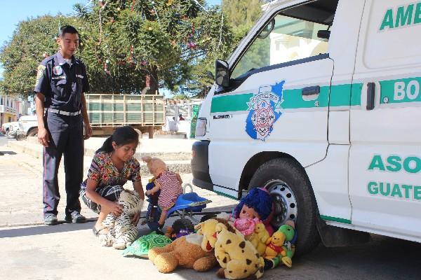 Un bombero de Patzún  recibe un donativo de juguetes por parte de una vecina.