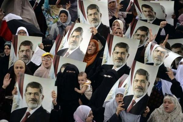 Unas mujeres egipcias partidarias de los Hermanos Musulmanes sostienen retratos de Mursi, el 21 de julio en El Cairo. (Foto Prensa Libre: AFP)