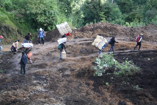 Personas cruzan el área del derrumbe, por la necesidad de llegar a sus destinos.