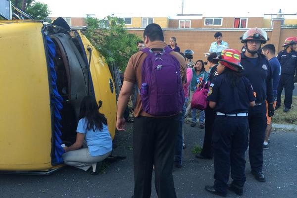 Bus escolar vuelca en la calle principal de la colonia Catalina y Terranova. (Foto Prensa Libre: Bomberos Municipales)