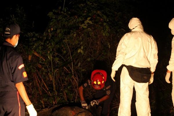 Bomberos Municipales y peritos del Ministerio Público observan el tonel donde fue localizado el cadáver. (Foto Prensa Libre: Danilo López)<br _mce_bogus="1"/>