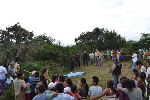 Curiosos y agentes de la Policía observan el cadáver localizado en el basurero de Teculután, Zacapa. (Foto Prensa Libre: Érick de La Cruz)<br _mce_bogus="1"/>