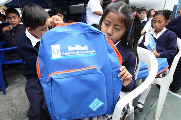 Niños de la escuela Complejo para la Paz y Rodolfo Robles con mochilas azul y naranja participan en el acto de inauguración del ciclo escolar. (Foto Prensa Libre: Paulo Raquec)