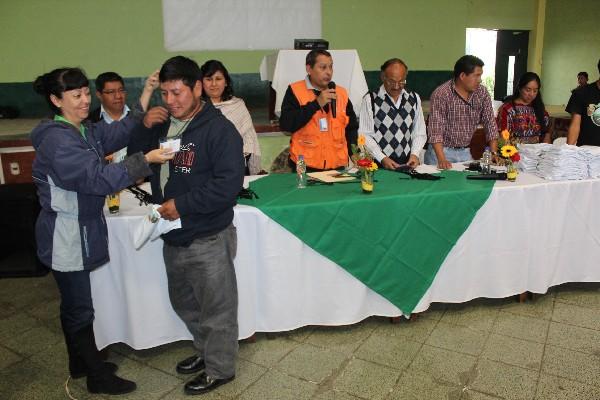 Un líder comunitario  de Chimaltenango recibe gafete que lo acredita como miembro de un comité de gestión de riesgo.