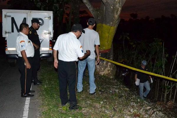 Agentes de la Policía y curiosos observan el área donde fue hallado en cadáver del hombre. (Foto Prensa Libre: Alexánder Coyoy)<br _mce_bogus="1"/>