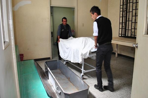 Dos empleados de una funeraria trasladan el cadáver de William Rodríguez, quien murió de un infarto en el Hospital Regional de Occidente, en Xela. (Foto Prensa Libre: Alejandra Martínez)