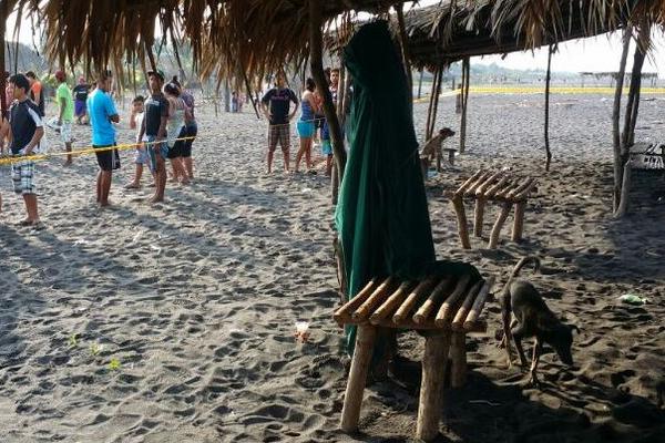 Vecinos observan el cadáver de la víctima en la playa de Champerico. (Foto Prensa Libre: Rolando Miranda)<br _mce_bogus="1"/>