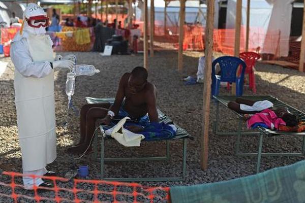 Un enfermero atiende a un paciente con ébola en Sierra Leona. (Foto Prensa Libre: AFP)