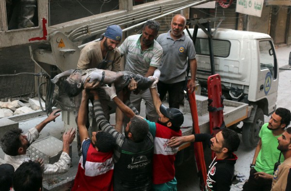 Un equipo de rescate recupera el cuerpo de un niño sirio tras un ataque en Alepo. (Foto Prensa Libre:AFP).