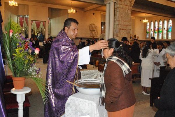 El padre Gabriel Perdomo coloca la cruz de ceniza en la frente de una mujer, en San Pedro Sacatepéquez. (Foto Prensa Libre: Aroldo Marroquín) <br _mce_bogus="1"/>