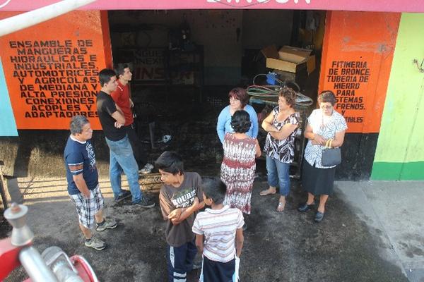 Vecinos permanecen frente a uno de los comercios afectados por el incendio en Mazatenango. (Foto Prensa Libre: Danilo López) <br _mce_bogus="1"/>