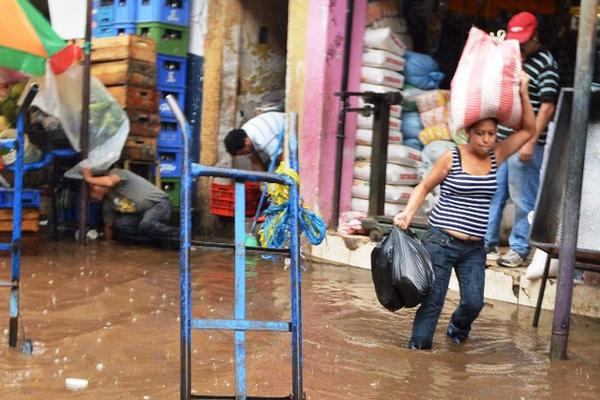 Agua anegada cubre calles y banquetas,  y se  introduce en los locales comerciales. (Foto Prensa Libre: Oswaldo Cardona)